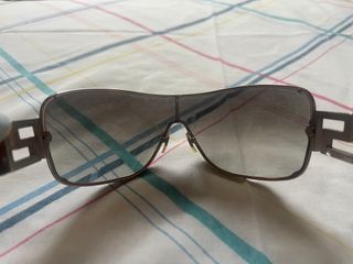 Gafas de sol Versace negras, detalle de joyas.