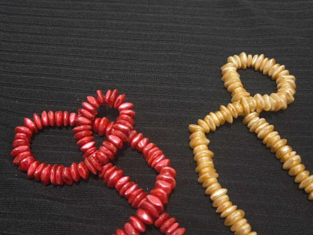 Collares largos de cuentas doradas y rojas