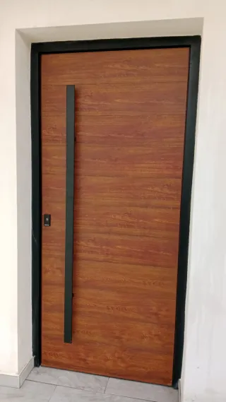 Puerta aluminio entrada, con marco color negro.