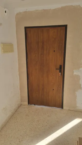 Puerta aluminio entrada, con marco color negro.