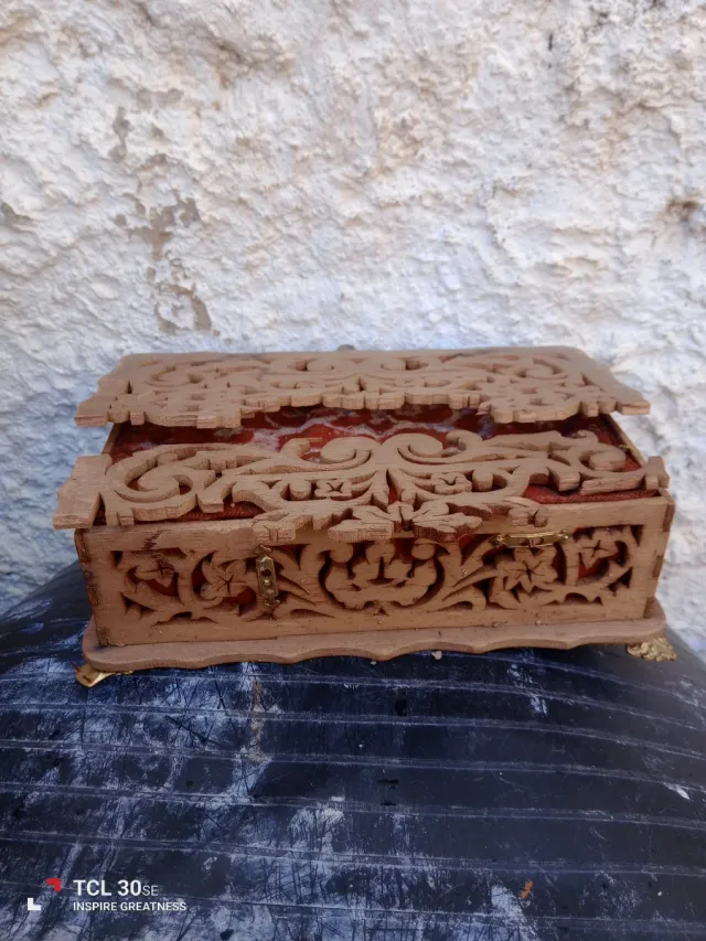 Caja  antigua de madera tallada con detalles.
