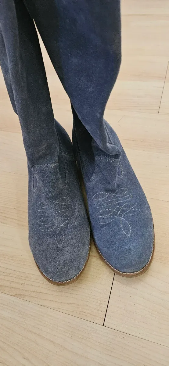 Botas altas de mujer ante azul claro