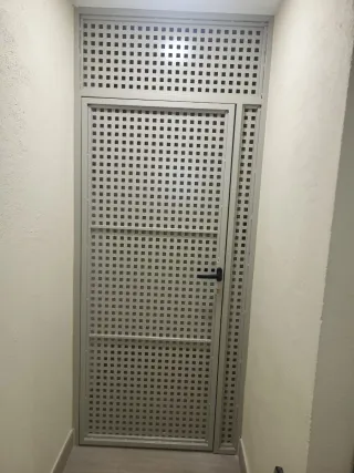 Puerta de metal negra con rejas blancas