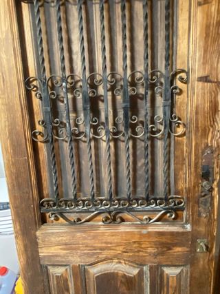 Puerta  de entrada y marco de madera y forja.