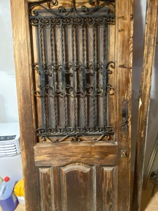 Puerta  de entrada y marco de madera y forja.
