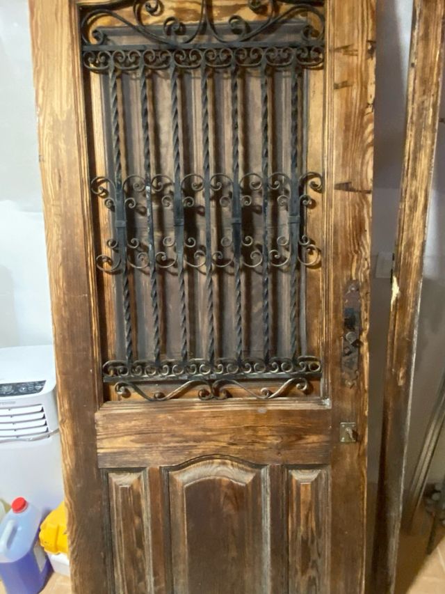 Puerta  de entrada y marco de madera y forja.