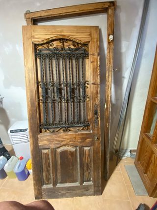 Puerta  de entrada y marco de madera y forja.