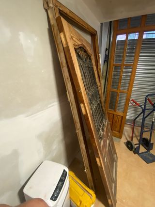 Puerta  de entrada y marco de madera y forja.