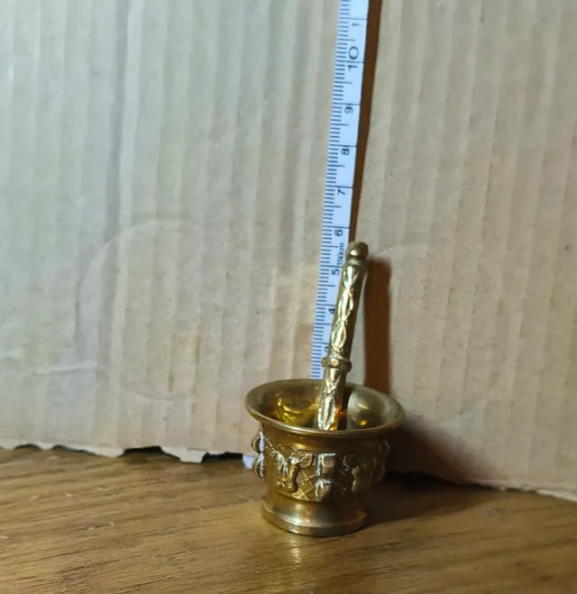 Mortero y mano de latón decorado