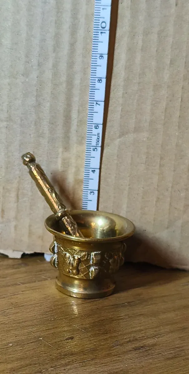 Mortero y mano de latón decorado