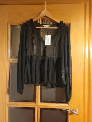 Camisa negra de lunares transparente y volante.