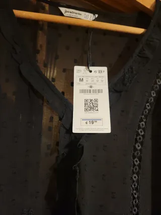 Camisa negra de lunares transparente y volante.