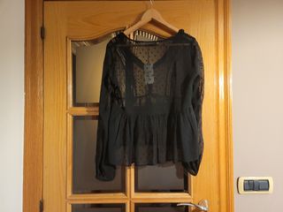 Camisa negra de lunares transparente y volante.