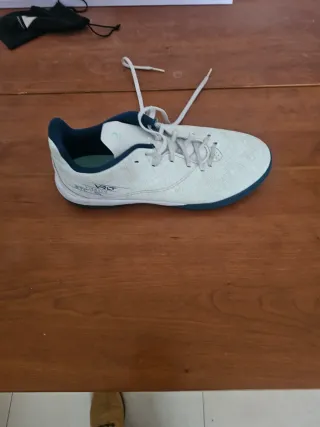 Botas de fútbol pista marca Kipsta, blancas y azul