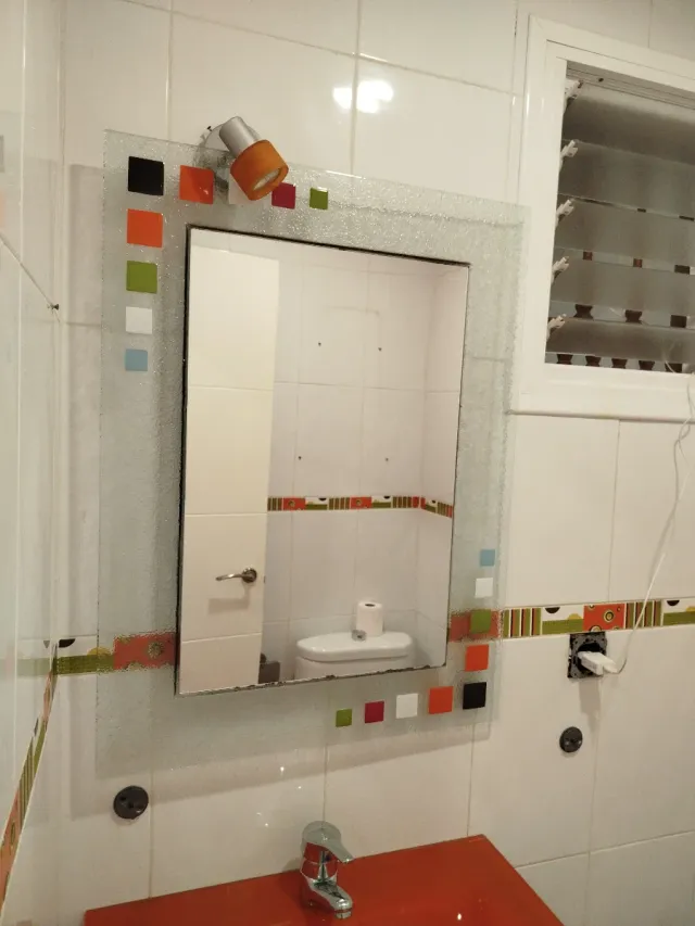 Lavabo de cristal naranja y espejo