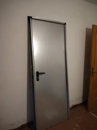 Puerta metálica con manilla negra
