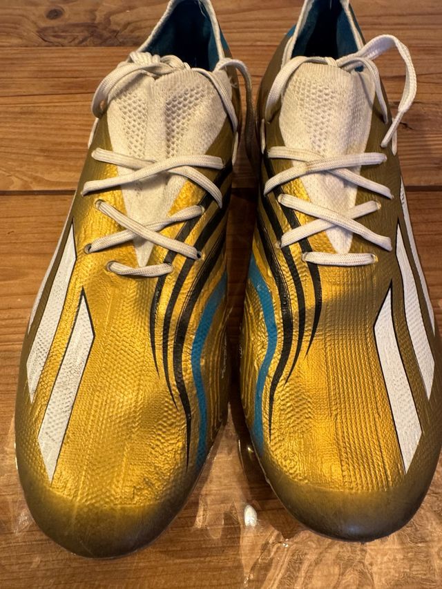 Botines de fútbol dorados y blancos