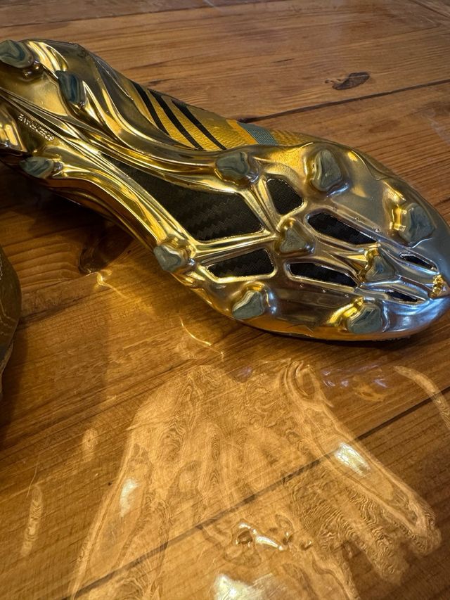 Botines de fútbol dorados y blancos