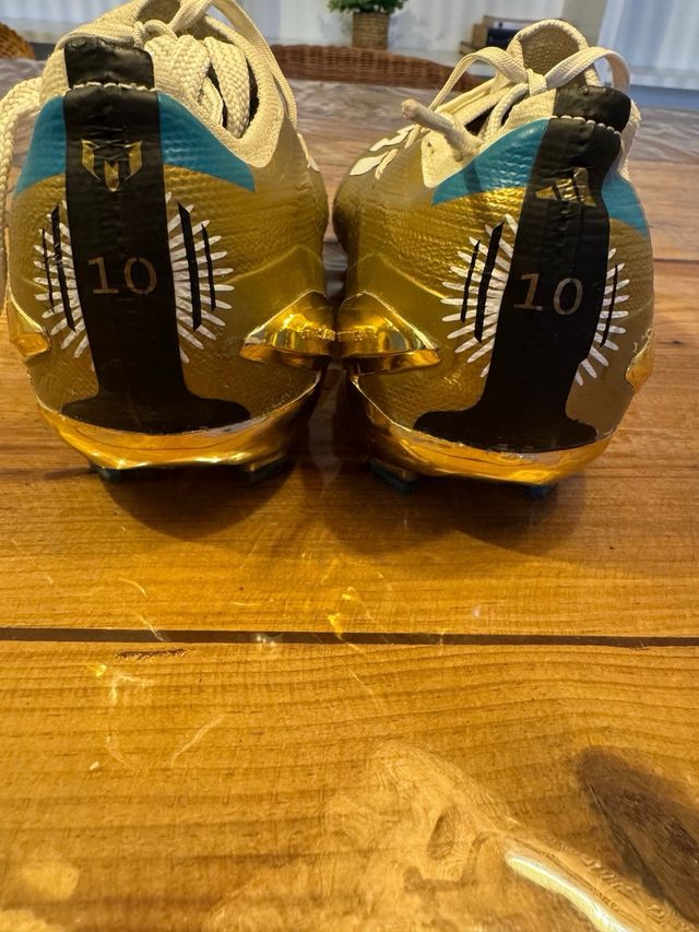 Botines de fútbol dorados y blancos