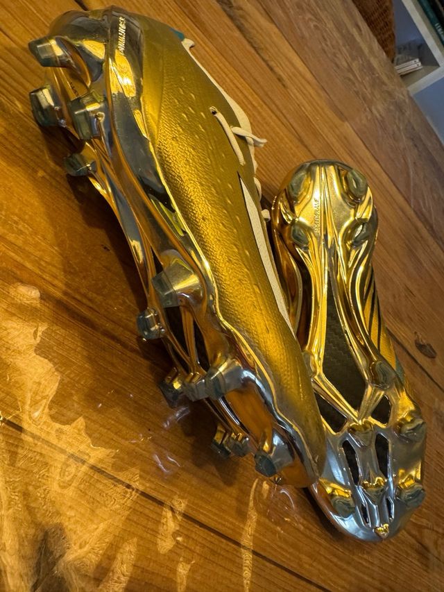 Botines de fútbol dorados y blancos