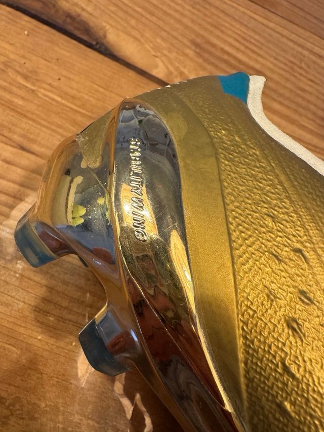 Botines de fútbol dorados y blancos