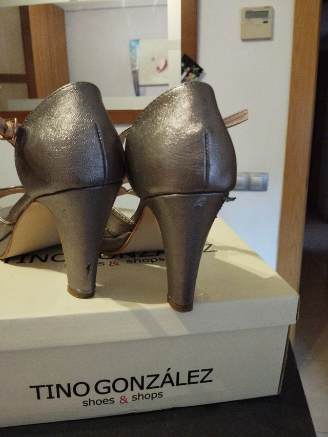 Zapatos de salón color oro y los tacones  dañados