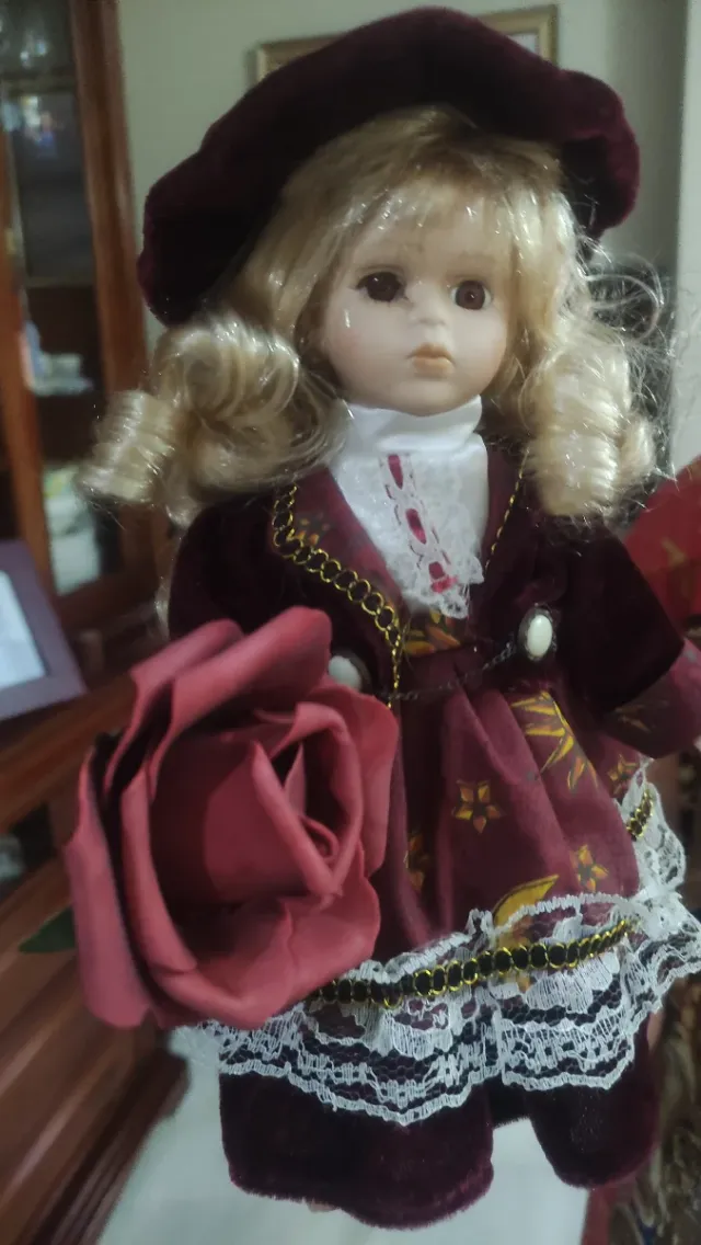 Muñeca de porcelana con vestido burdeos