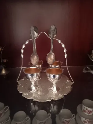 Huevera de apariencia plata con 4 copas y 2 cuchar