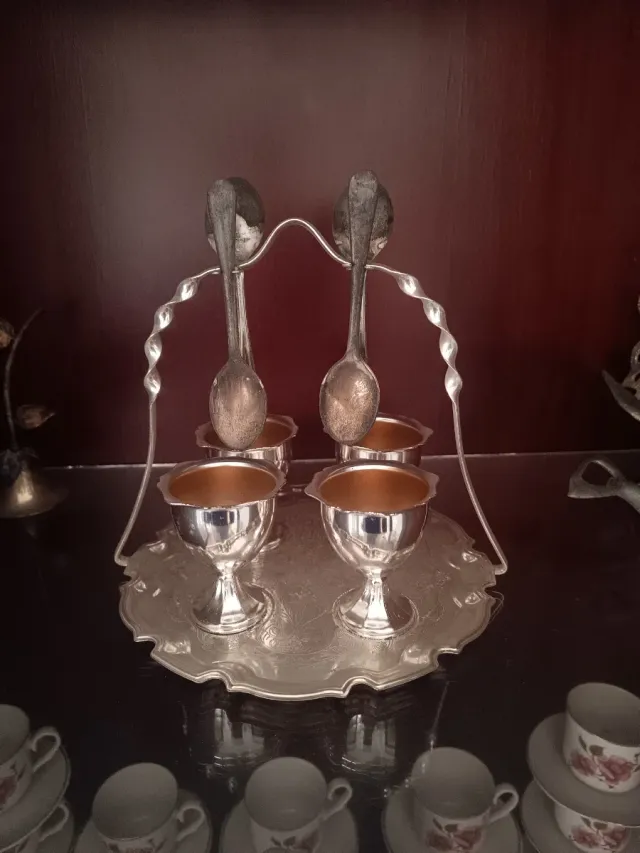 Huevera de apariencia plata con 4 copas y 2 cuchar