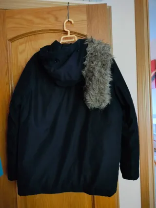 Chaquetón negro con capucha y pelo, muy calentito.