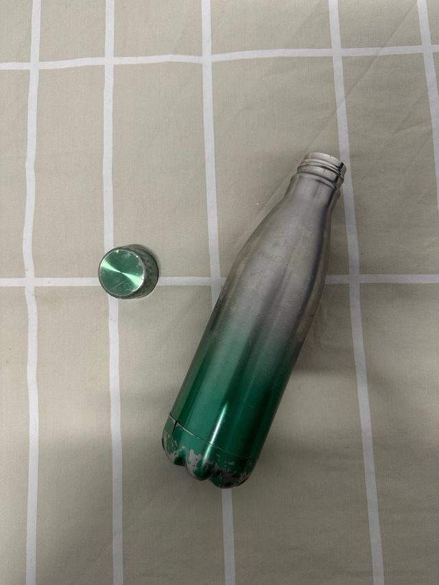 Botella de metal verde y plateada