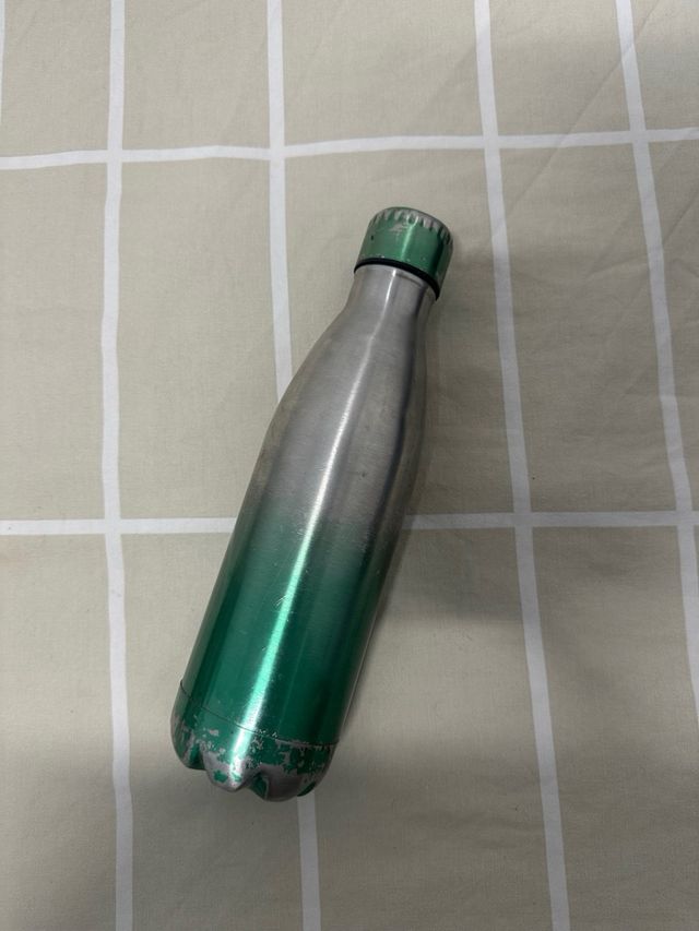 Botella de metal verde y plateada