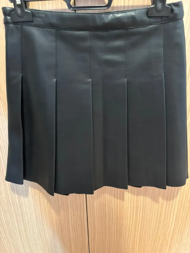 Falda de cuero negra con tablas