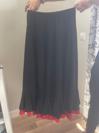 Falda flamenca larga negra con volantes rojos.