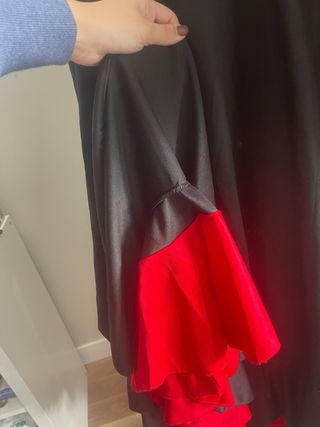 Falda flamenca larga negra con volantes rojos.
