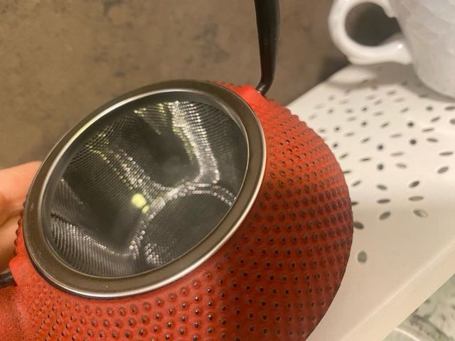 Tetera de metal roja con asa negra