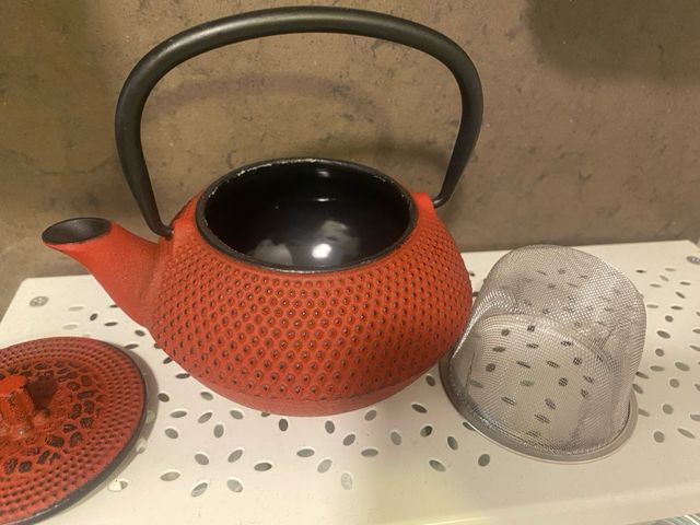 Tetera de metal roja con asa negra