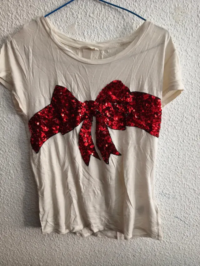 Camiseta beige con lazo lentejuelas rojas