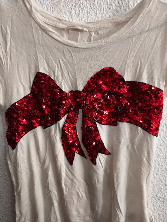 Camiseta beige con lazo lentejuelas rojas