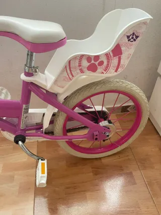 Bicicleta infantil rosa con asiento trasero