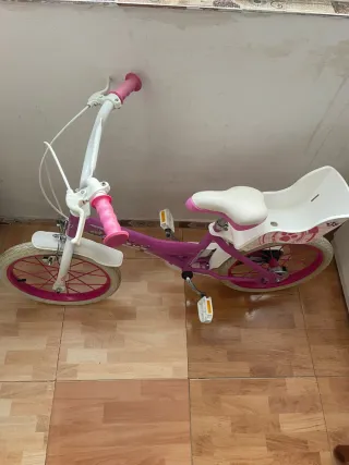 Bicicleta infantil rosa con asiento trasero