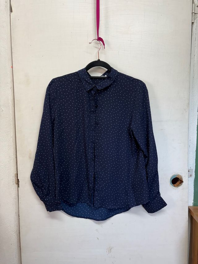 Camisa azul con lunares blancos.