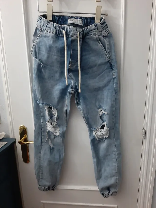 Vaqueros desgastados con rotos y puño