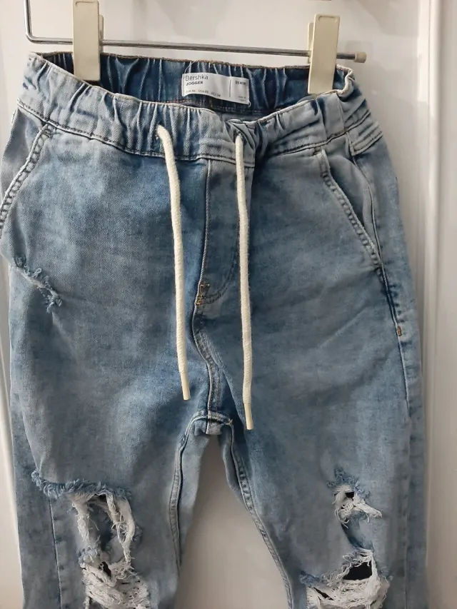 Vaqueros desgastados con rotos y puño