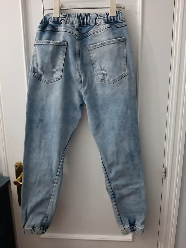 Vaqueros desgastados con rotos y puño