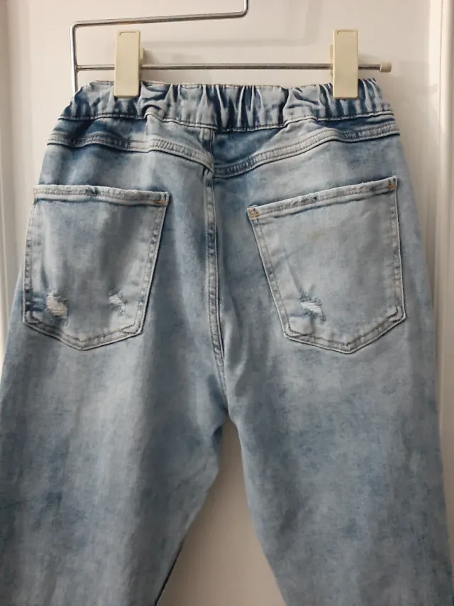 Vaqueros desgastados con rotos y puño