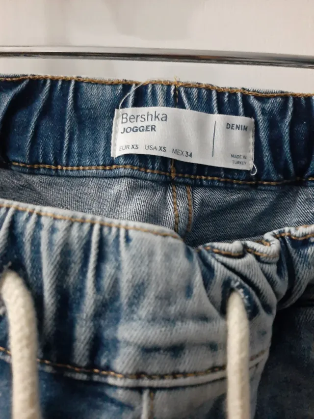 Vaqueros desgastados con rotos y puño