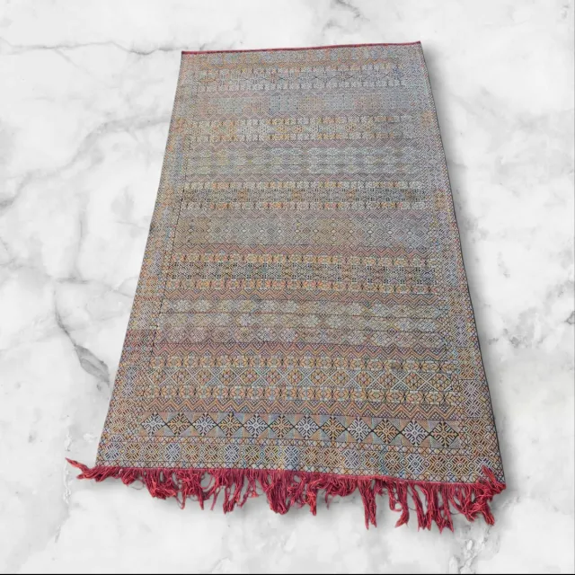 Alfombra tejida multicolor con flecos