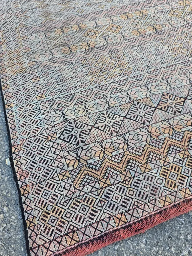 Alfombra tejida multicolor con flecos