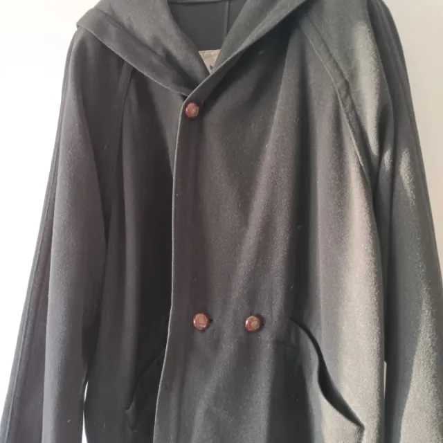 Trenca con capucha negra, fabricada en España.